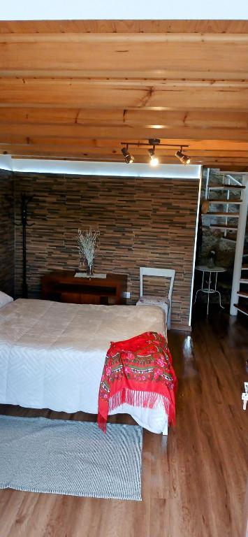 a bedroom with a bed and a brick wall at CASA DA QUELHA in Soajo