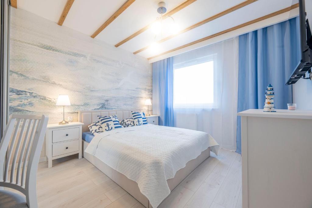 Ένα ή περισσότερα κρεβάτια σε δωμάτιο στο Kapitański by Go Apart