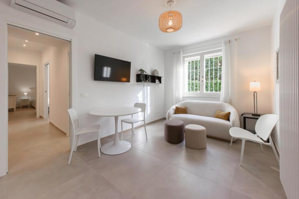 Una sala de estar con un sofá, una mesa y sillas. en GOLDEN LUXE - New Style in Forte dei Marmi Private Parking, en Forte dei Marmi