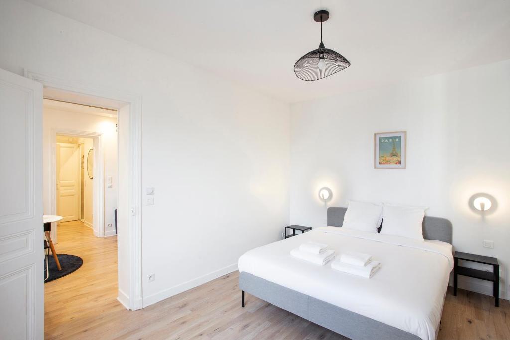 a white bedroom with a bed and a hallway at Luxury apartment saint mande 5 minuts from Paris in Saint-Mandé