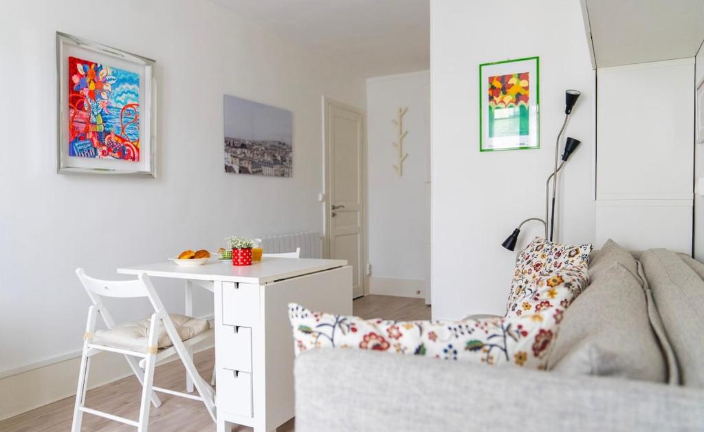- un salon blanc avec une table et une chaise dans l'établissement Cosy studio Métro 14, 13, à Paris
