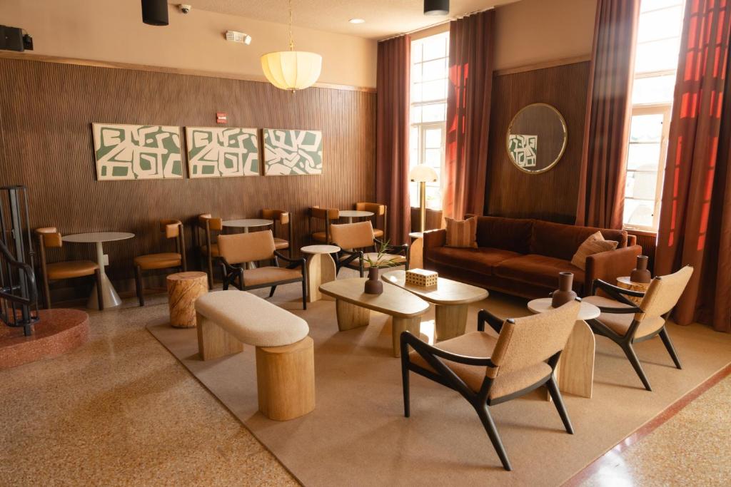 a lobby with a couch and tables and chairs at FOUND Hotel Miami Beach in Miami Beach