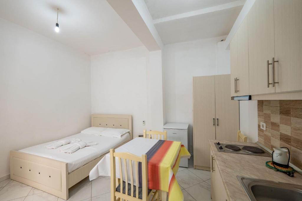 a small room with a bed and a kitchen at Vila Celi in Sarandë