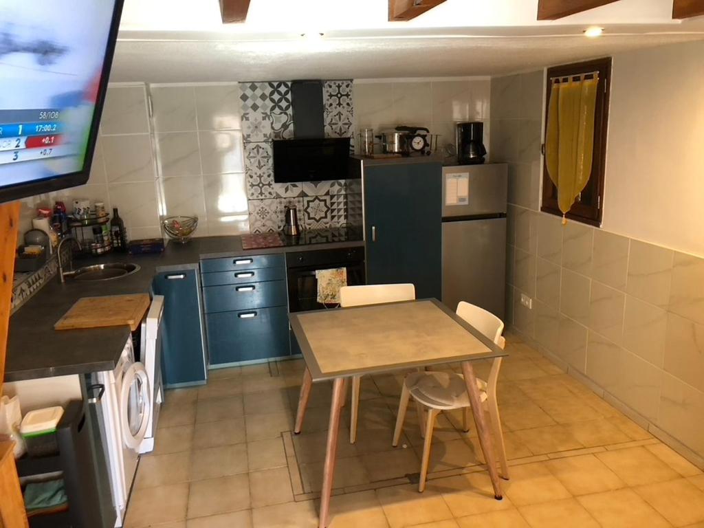 une cuisine avec une table et une cuisine avec des armoires bleues dans l'établissement Mon Rêve, à Saint Cyprien Plage