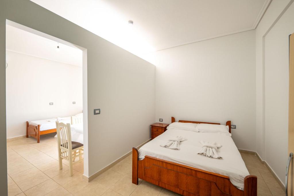 a bedroom with a bed and a table and a chair at Vila Celi in Sarandë