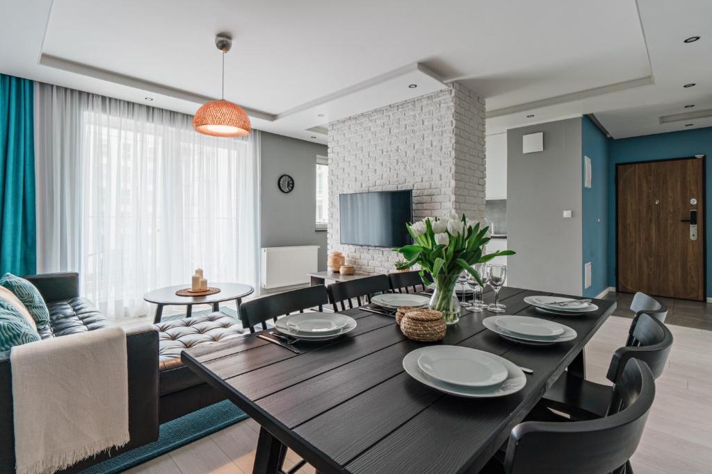 uma sala de jantar e sala de estar com mesa e cadeiras em Apartament Aurora, Free parking em Gdańsk