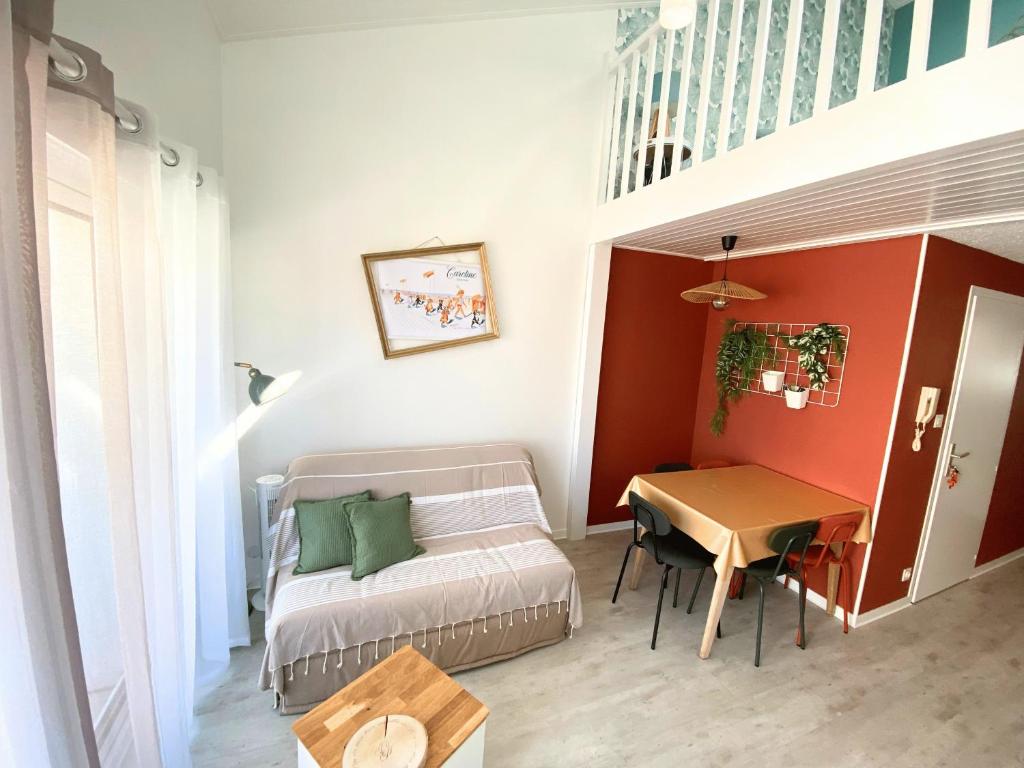 Cette petite chambre comprend un canapé et une table. dans l'établissement Le doux refuge aperçu mer, à Les Sables-dʼOlonne