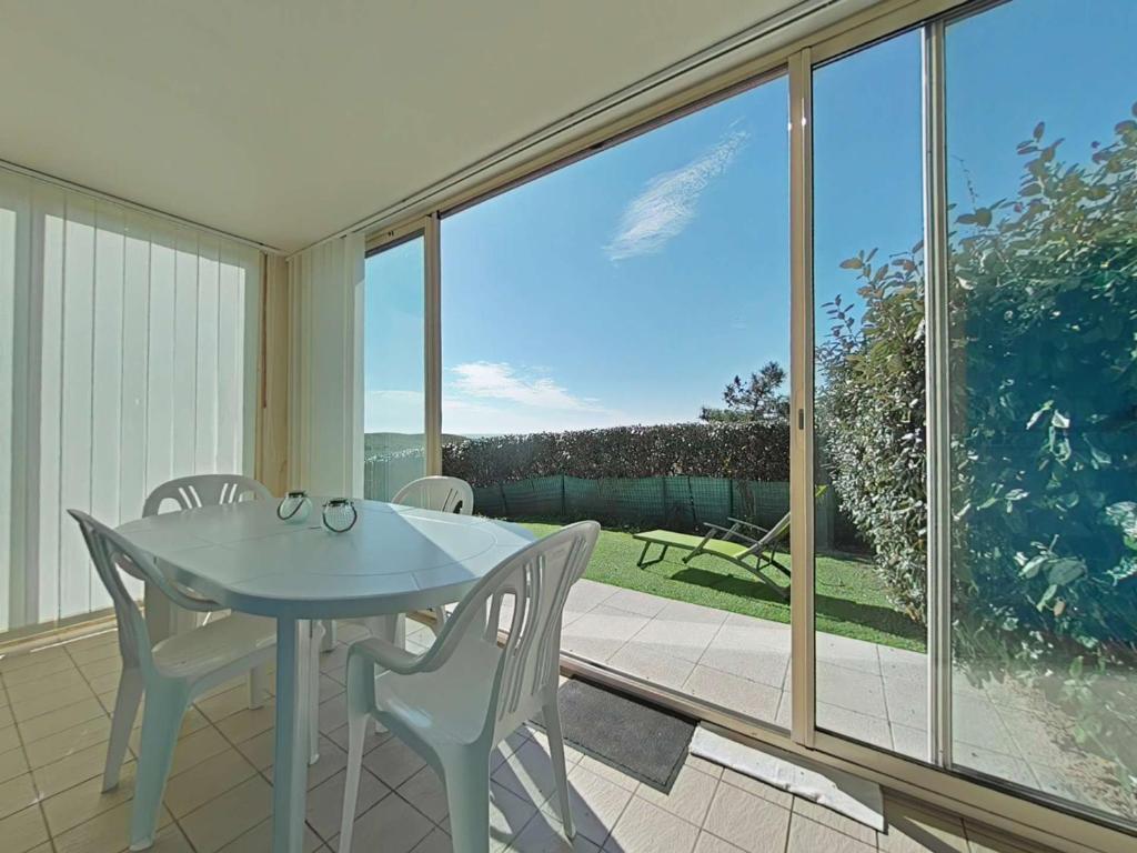 une salle à manger avec une table et des chaises sur un balcon dans l'établissement Maison à Bretignolles-sur-Mer : 2 ch, 4 pers, piscine sécurisée - FR-1-224A-39, à Bretignolles-sur-Mer