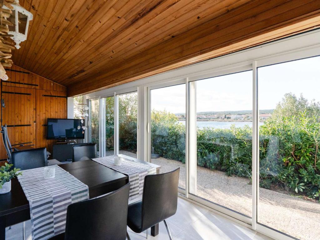 une salle à manger avec une table, des chaises et des fenêtres dans l'établissement Pavillon 2 pièces mezzanine, 5 pers, WIFI, animaux admis - FR-1-409-40, à Gruissan