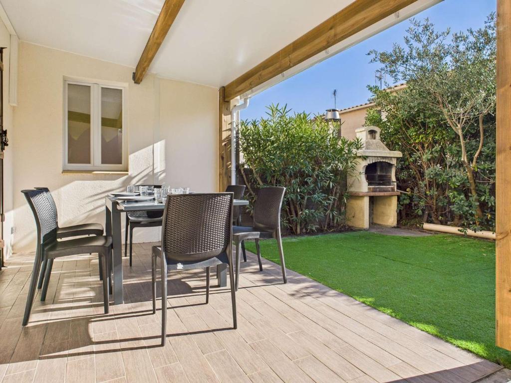 d'une terrasse avec une table et des chaises ainsi que d'un jardin. dans l'établissement Appartement duplex climatisé avec terrasse, 1 chambre, parking privé, proche plage - FR-1-326-559, à Marseillan