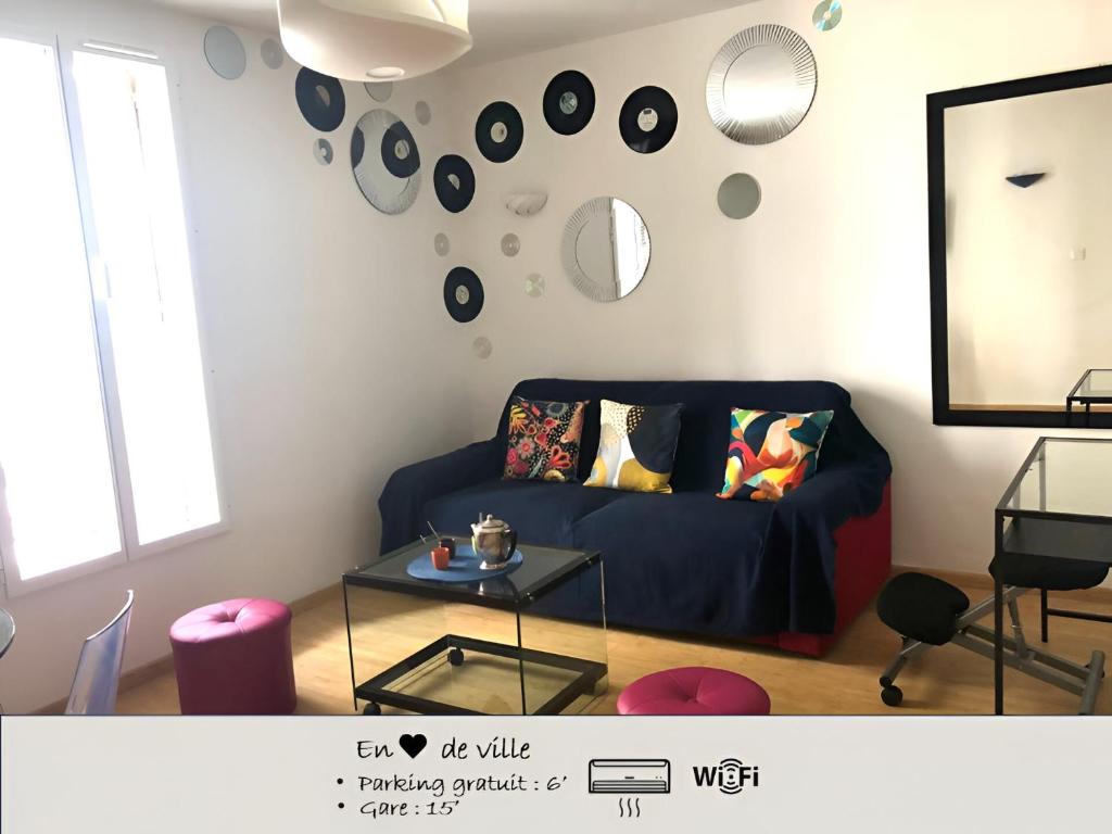 un salon avec un canapé bleu et une table dans l'établissement En cœur de ville et climatisé - Le Off Sète, à Sète