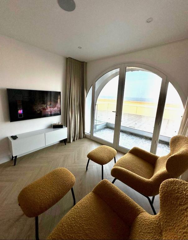 un soggiorno con sedie e una grande finestra di Le One - Villa la Potinière - mer a Dunkerque