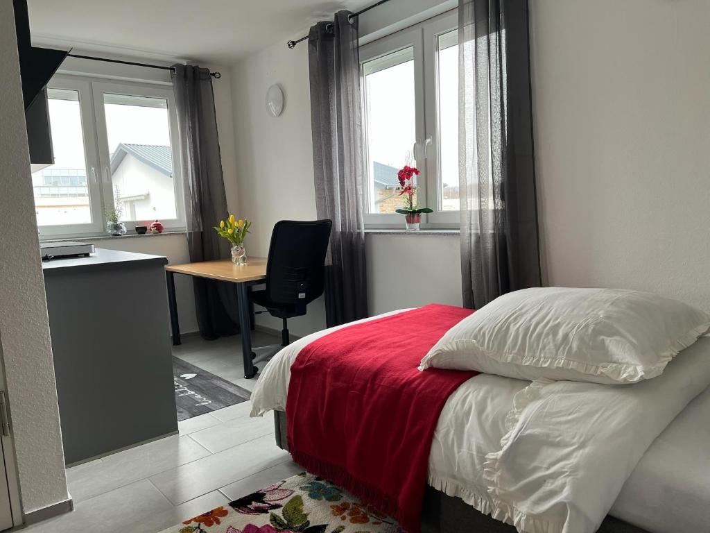 a bedroom with a bed and a desk and windows at ODA Living & Home in Frankfurt/Main