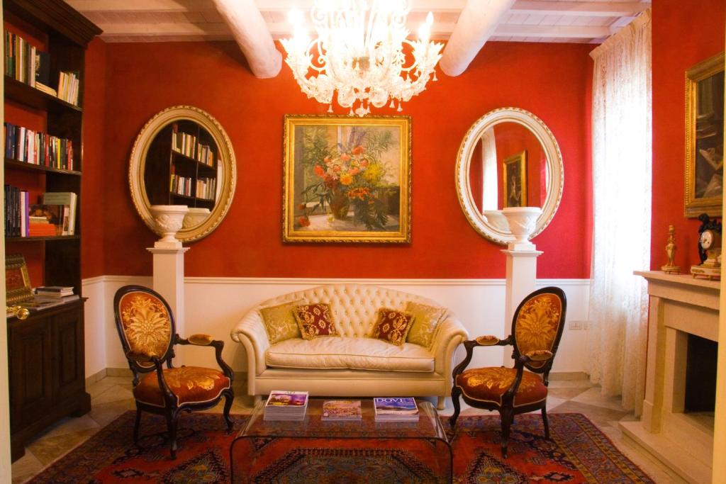a living room with a couch and two mirrors at B&B A Casa Dell'Antiquario in San Benedetto Po