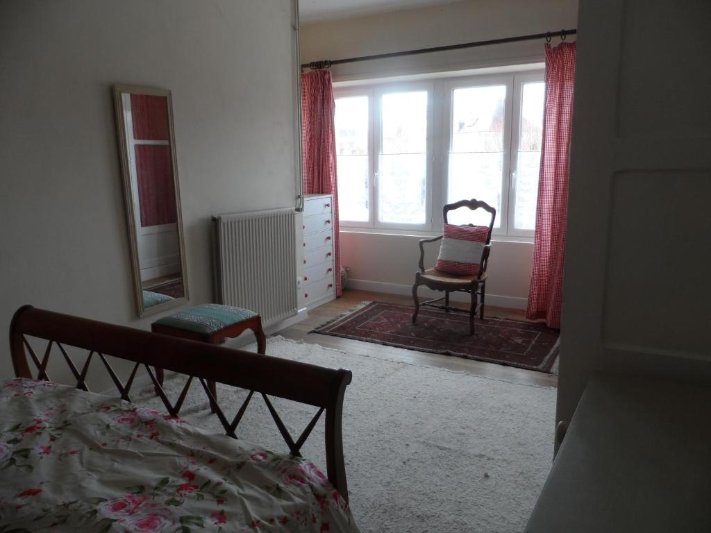 a bedroom with a bed and a chair and a mirror at Appartements Yzeures Sur Creuse in Yzeures-sur-Creuse