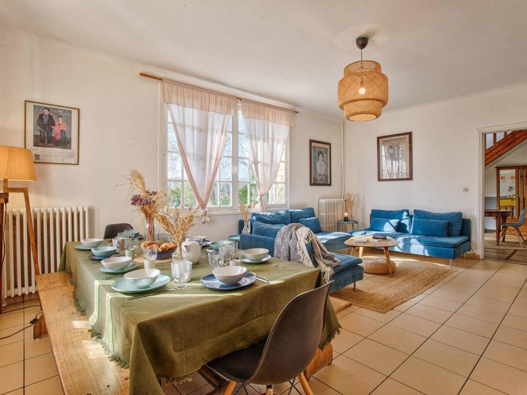 un salon avec une table et un canapé bleu dans l'établissement Maison familiale avec sauna et ferme proche plage - FR-1-788-49, à Gonneville-en-Auge
