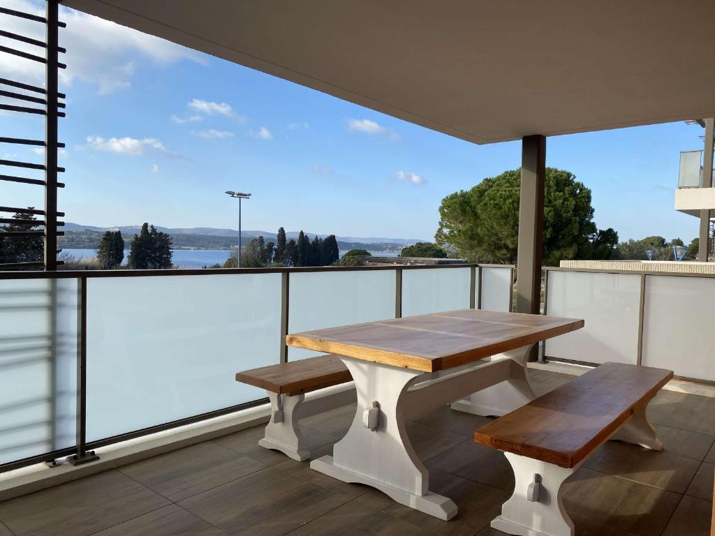 d'une table et de deux bancs sur un balcon avec vue. dans l'établissement Appartement T3 moderne avec terrasse et parking sécurisé - FR-1-553-293, à Balaruc-les-Bains