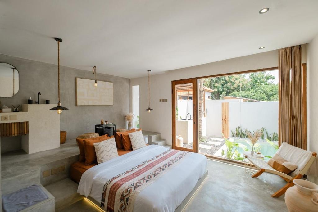 Un dormitorio con una cama grande y una ventana grande. en Canna Uluwatu - Stylish Private 1BR Pool Suite, en Uluwatu