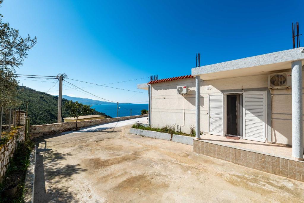 a house with a road next to a building at Vila Celi in Sarandë