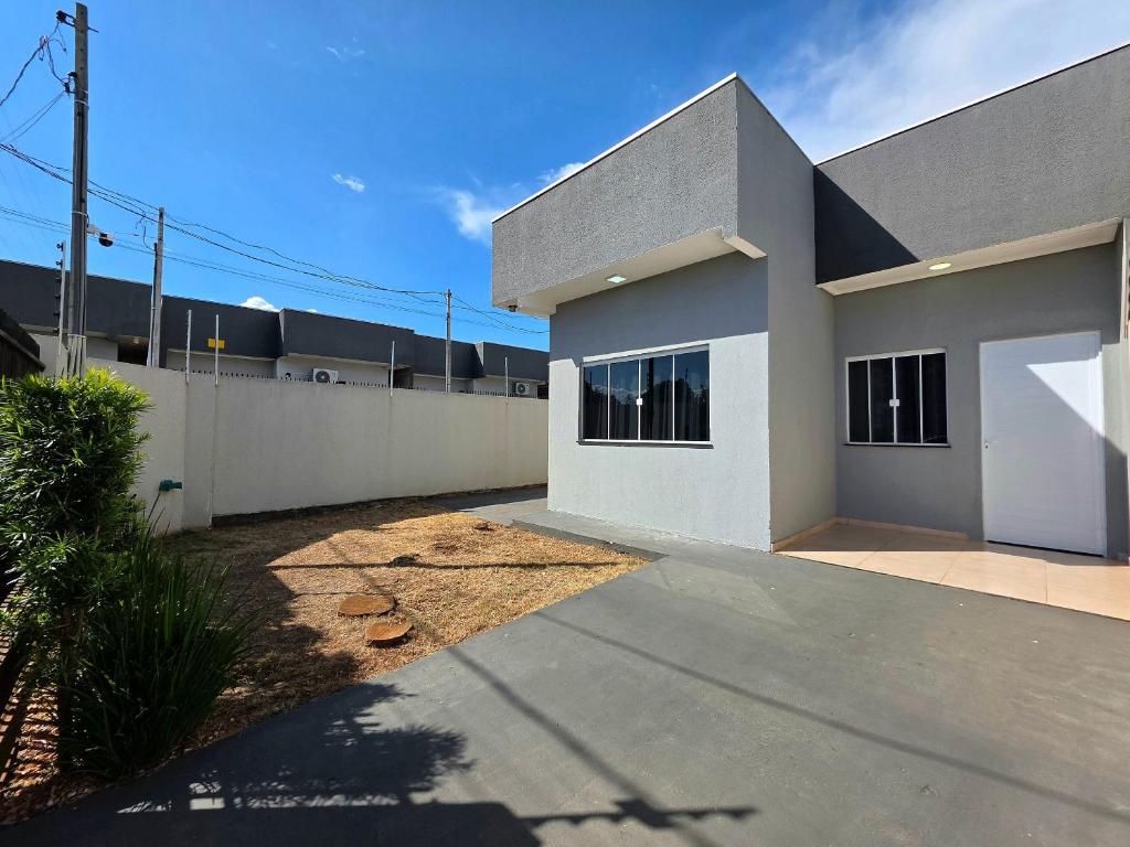 a white house with a fence and a driveway at 2 quartos prox centro, Argentina, Marco 3 front in Foz do Iguaçu
