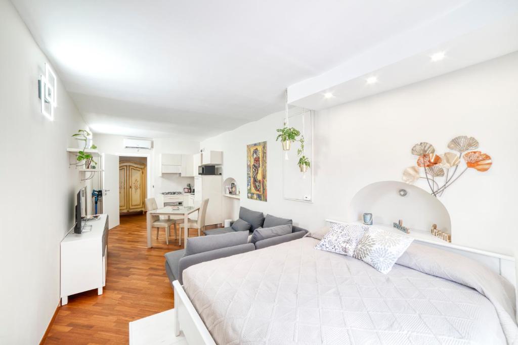Un dormitorio blanco con una cama y un sofá. en Il Cri Cri, en Turín