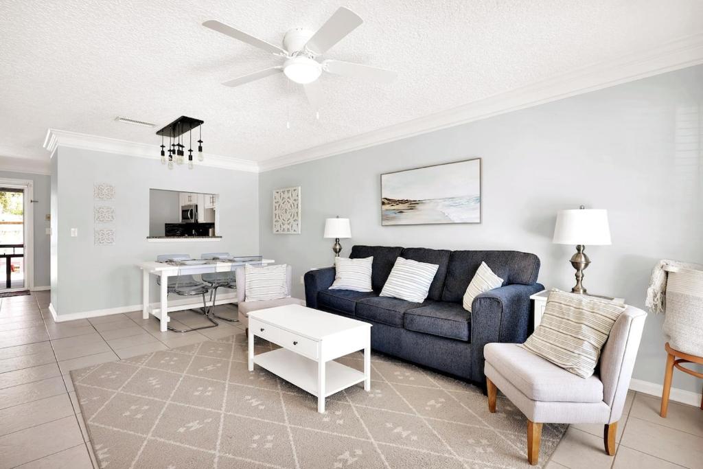 Una sala de estar con un sofá azul y una mesa. en Steps to the Beach from this Salt Air Home, en Jacksonville Beach