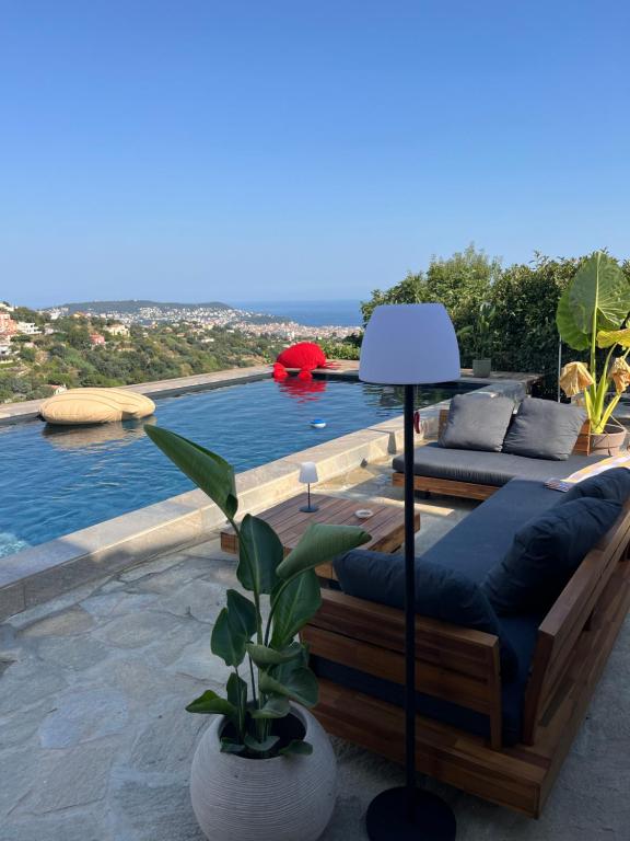une terrasse avec une piscine dotée d'un canapé et d'une lampe dans l'établissement Villa location saisonniere, à Nice