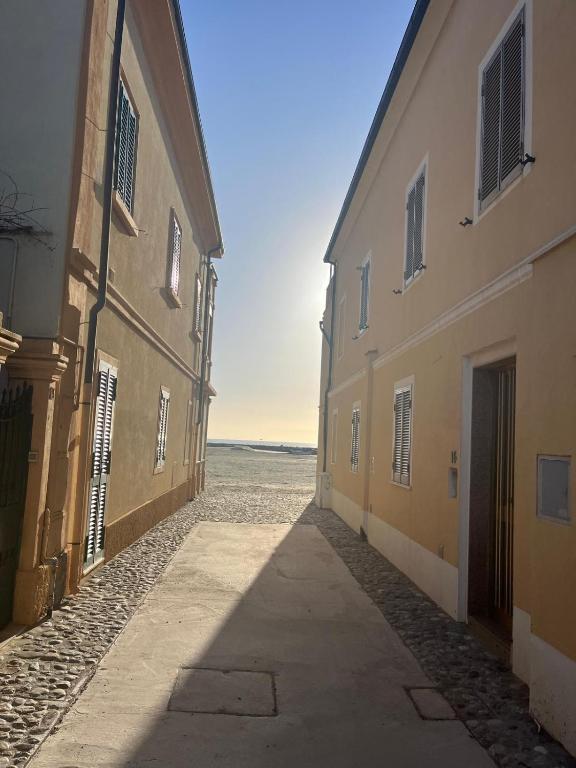 an empty alley way between two buildings with the ocean in the background at Appartamento Margarita Maris - 20mt dalla Spiaggia in Follonica