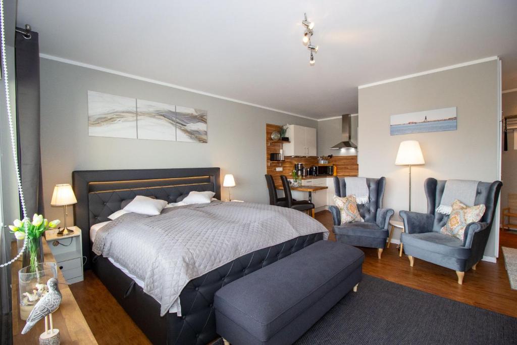 a bedroom with a bed and two chairs and a table at Atlantic 209 in Döse