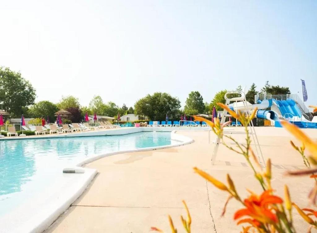 - une piscine dans un complexe avec toboggan dans l'établissement Bungalow confortable à Onzain avec piscine partagée, à Onzain