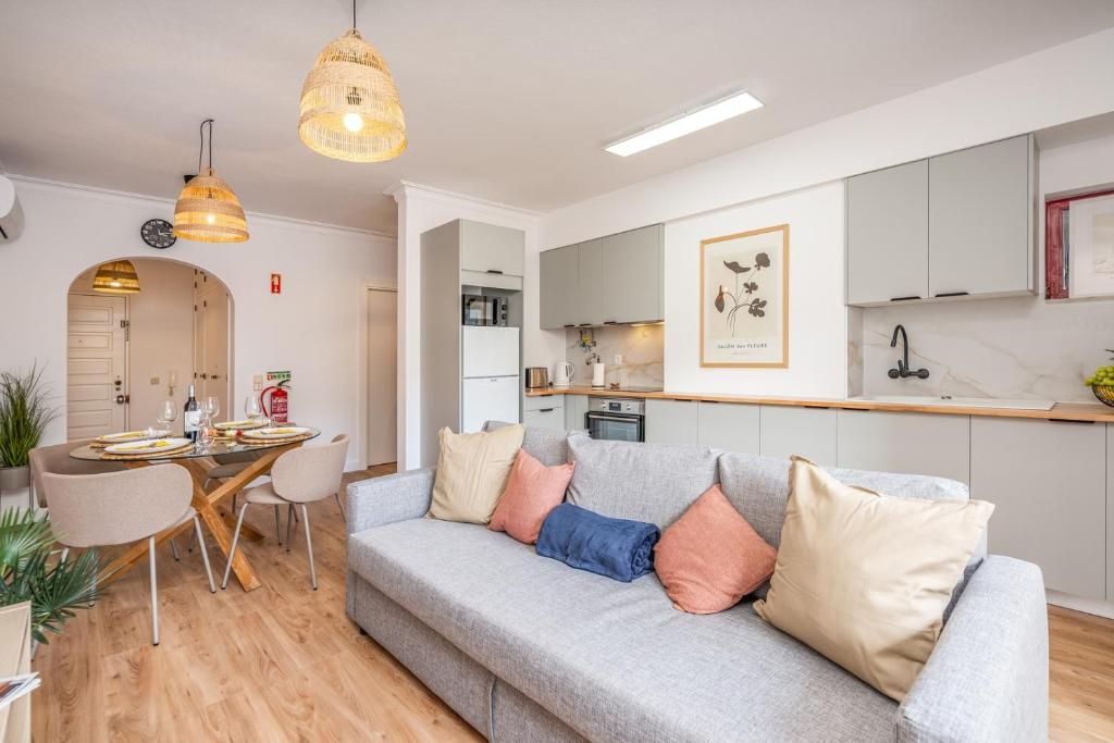 a living room and kitchen with a couch and a table at HostWise - Elegant & Stylish Flat w/ Balcony in Portimão