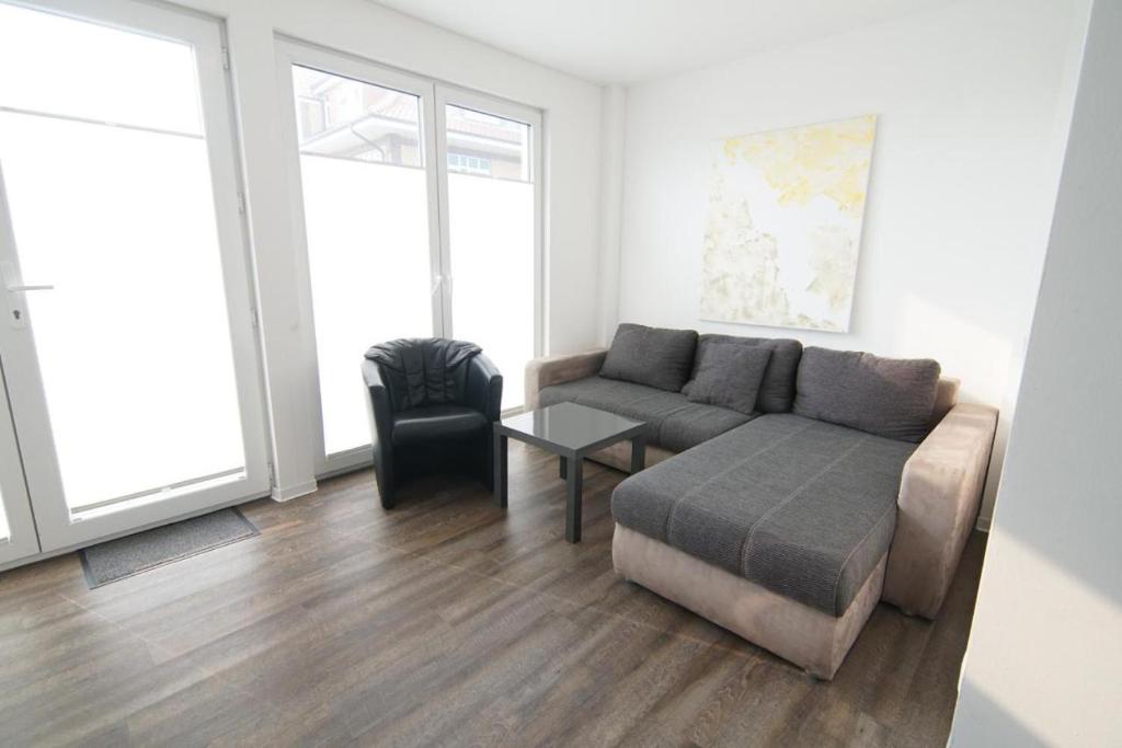a living room with a couch and a chair at Hafenloft App 3 in Norderney