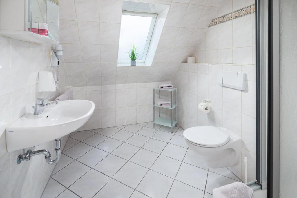 a white bathroom with a toilet and a sink at Mayglück App 3 in Norderney