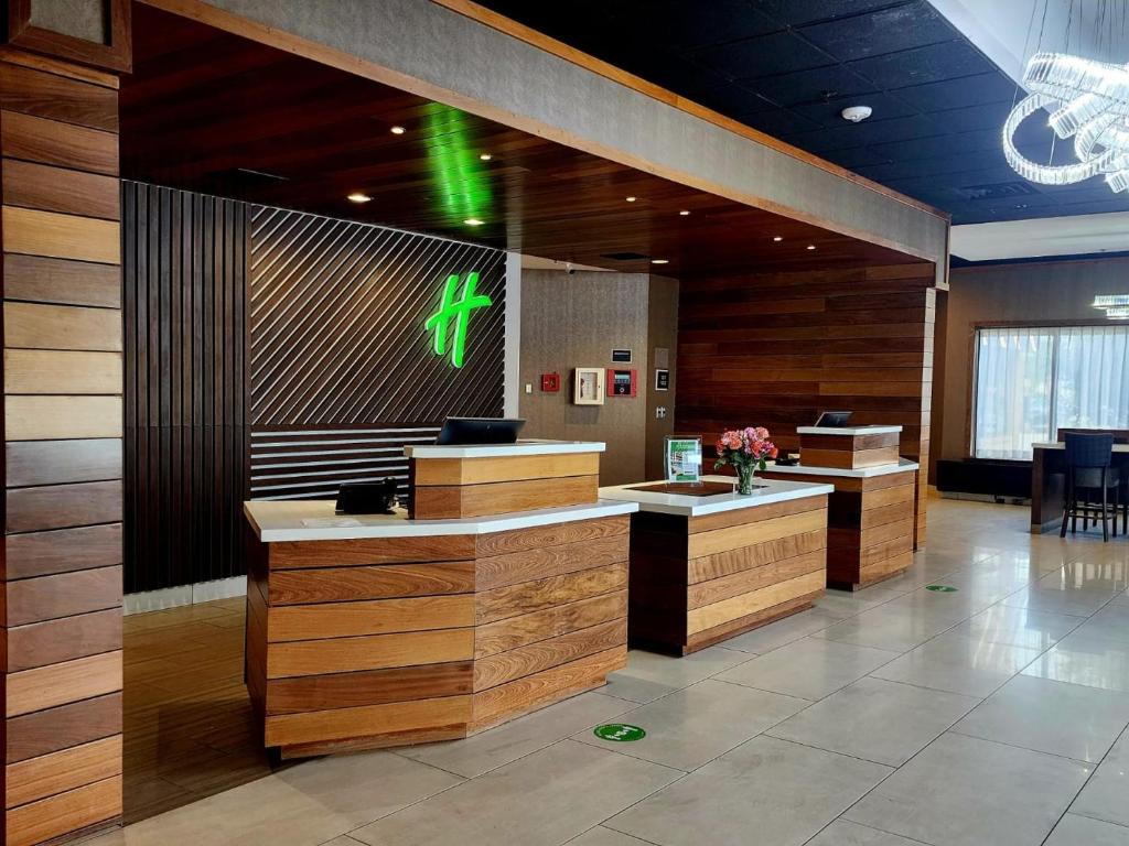 a lobby with wooden counters and a sign on the wall at Holiday Inn Brookfield - Milwaukee by IHG in Brookfield