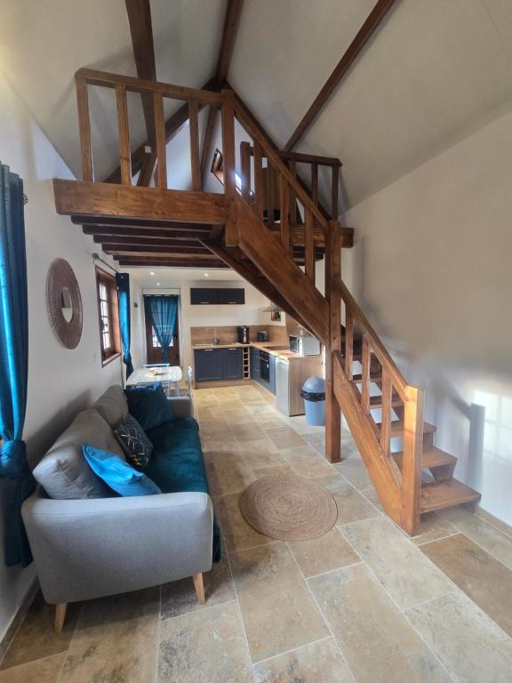 un salon avec un canapé et un escalier dans l'établissement Charmante Maison au calme, à Saint-Denis-le-Ferment