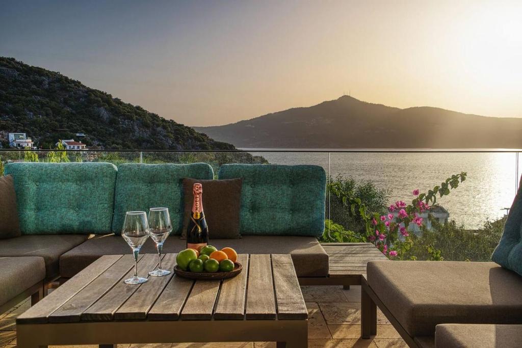 a table with two wine glasses and a bowl of fruit at Captivating Casa La Calypso in Kas