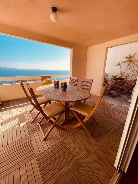 une salle à manger avec une table et des chaises sur un balcon dans l'établissement Ajaccio sanguinaires F3, à Ajaccio
