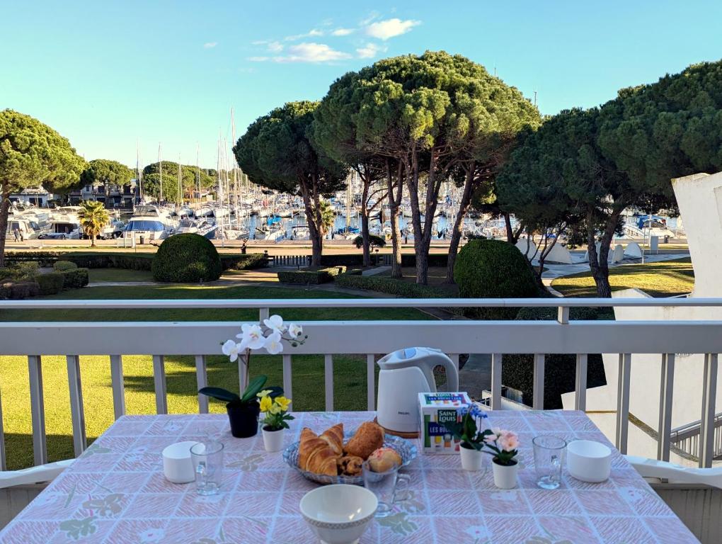 - une table avec de la nourriture sur un balcon avec vue sur le port dans l'établissement Sol-y-Days le Cormoran appartement vue sur port de plaisance, au Grau-du-Roi