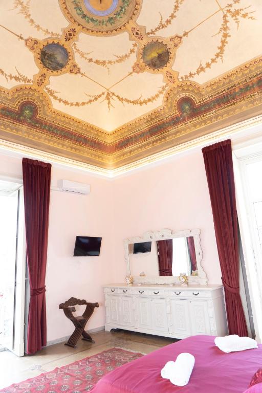 a bedroom with a ceiling with a bed and a mirror at ETNA QUEEN luxury home in Catania