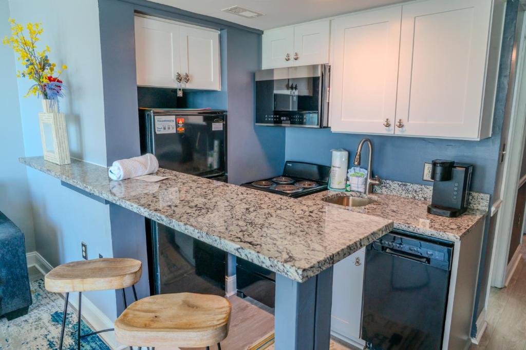 eine Küche mit einer Theke und 2 Hockern in der Unterkunft Ocean View Double Suite! Sleeps 4 Meridian Plaza 705 in Myrtle Beach