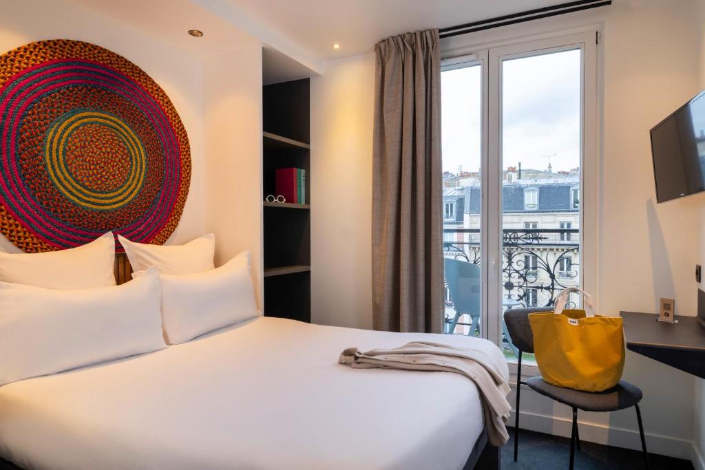 a hotel room with a bed and a large window at Korner Saint Marcel in Paris