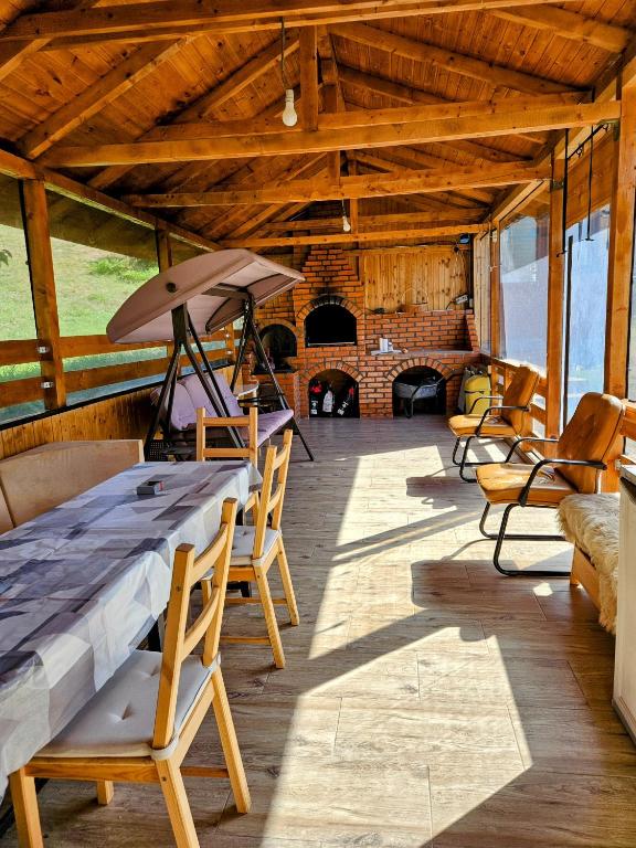 a room with a table and chairs and a fireplace at Undeva la Mosie in Podu Dîmboviţei