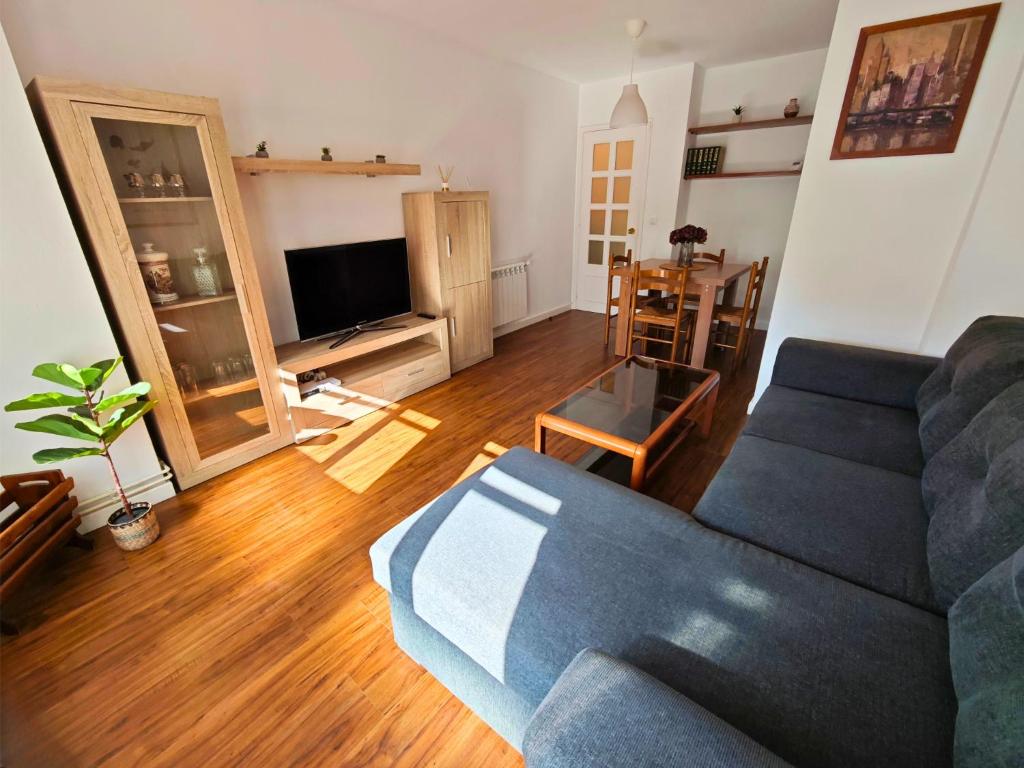 a living room with a blue couch and a table at Apartamento Pena Furada in Ribadeo