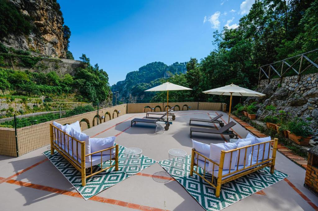 a patio with chairs and tables and umbrellas at The Lemon Garden Villa by Elite Villas in Pontone