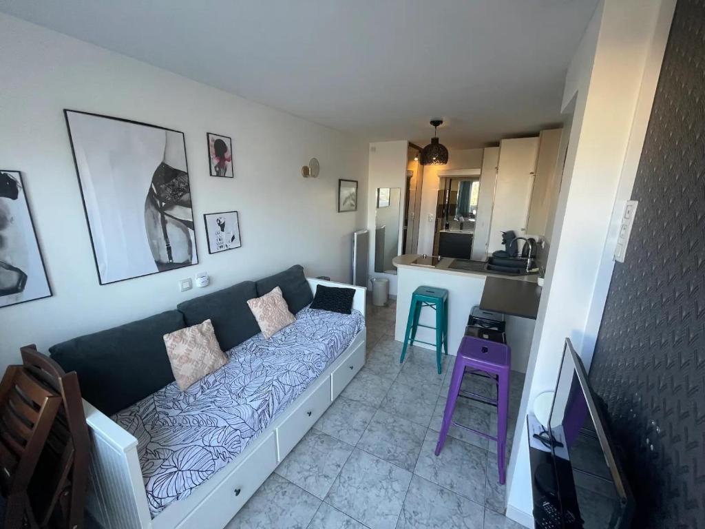 un salon avec un canapé et une cuisine dans l'établissement Studio 'Soleil et Liberté' - Village Naturiste, au Cap d'Agde