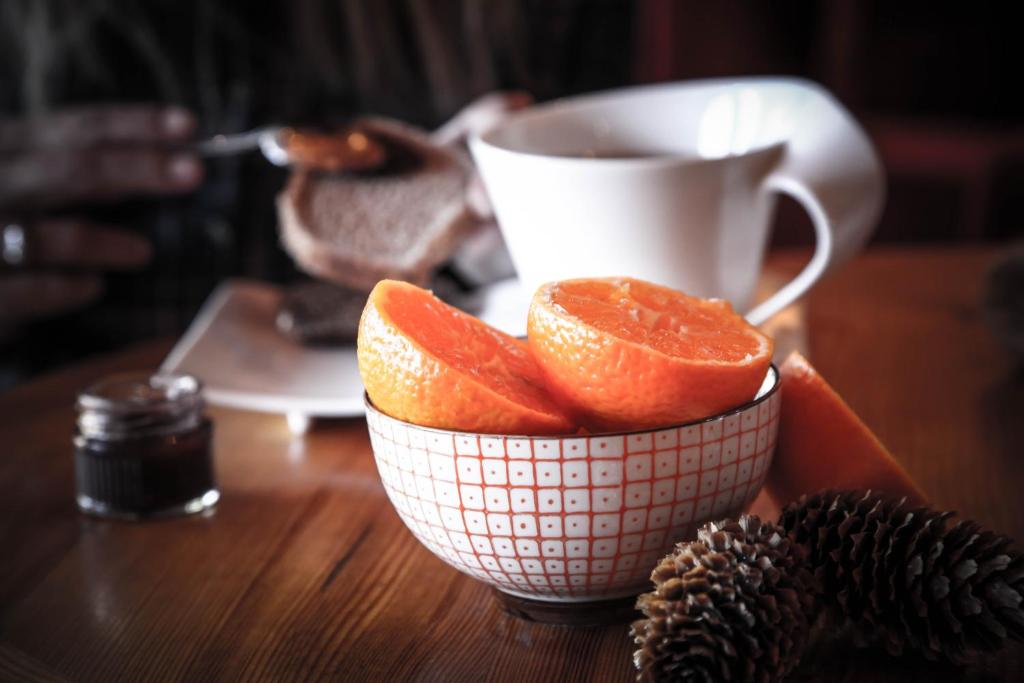 a bowl of oranges on a table with a cup of coffee at Hôtel Le Refuge in Tignes