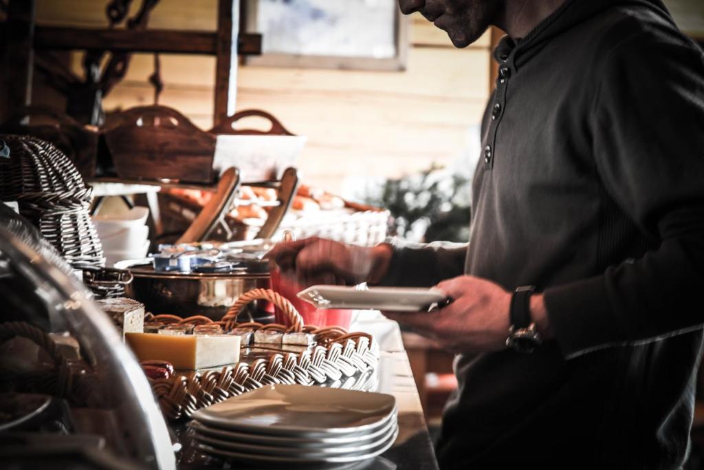 a man is preparing food in a kitchen at Hôtel Le Refuge in Tignes