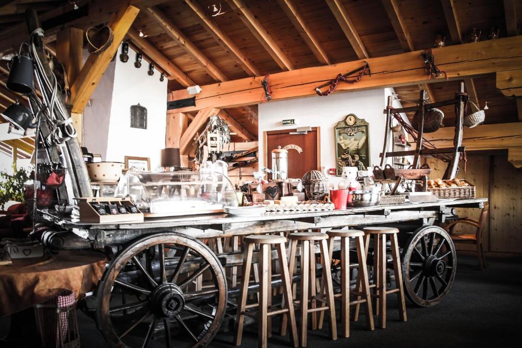 a room with a counter with stools and a table with food at Hôtel Le Refuge in Tignes