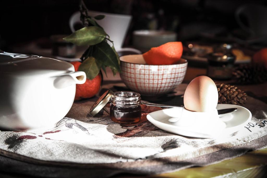 a table with a plate of eggs and a bowl of fruit at Hôtel Le Refuge in Tignes