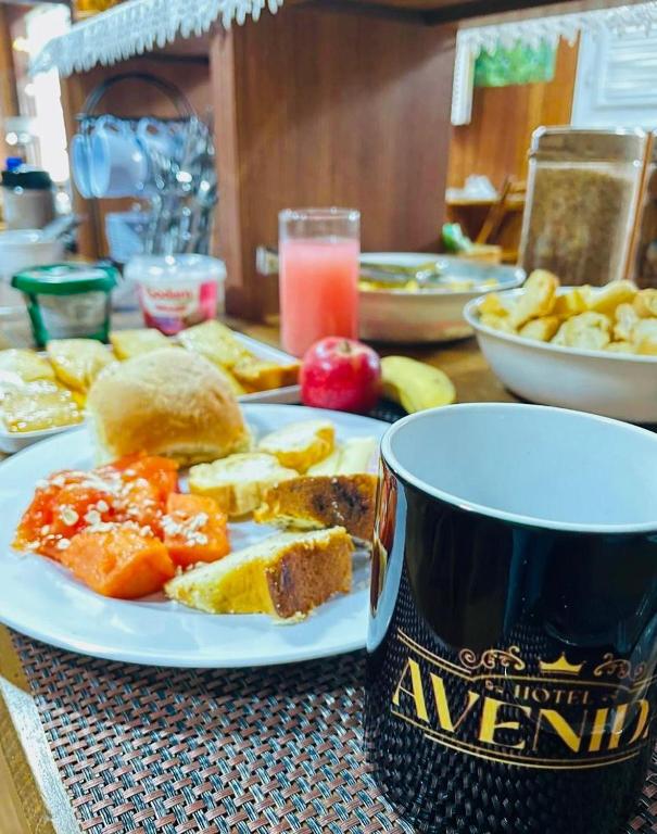 ノバ・フリブルゴにあるHotel Avenidaの食べ物の皿とコーヒーカップが置かれたテーブル